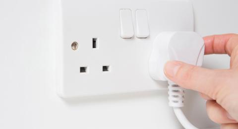White wall with white plug in socket
