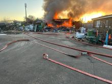 Firefighters tackling a recycling yard fire in the evening