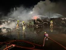 Firefighters tackling a recycling yard fire at night