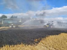 Firefighters at the scene of a tractor fire that spread to a field