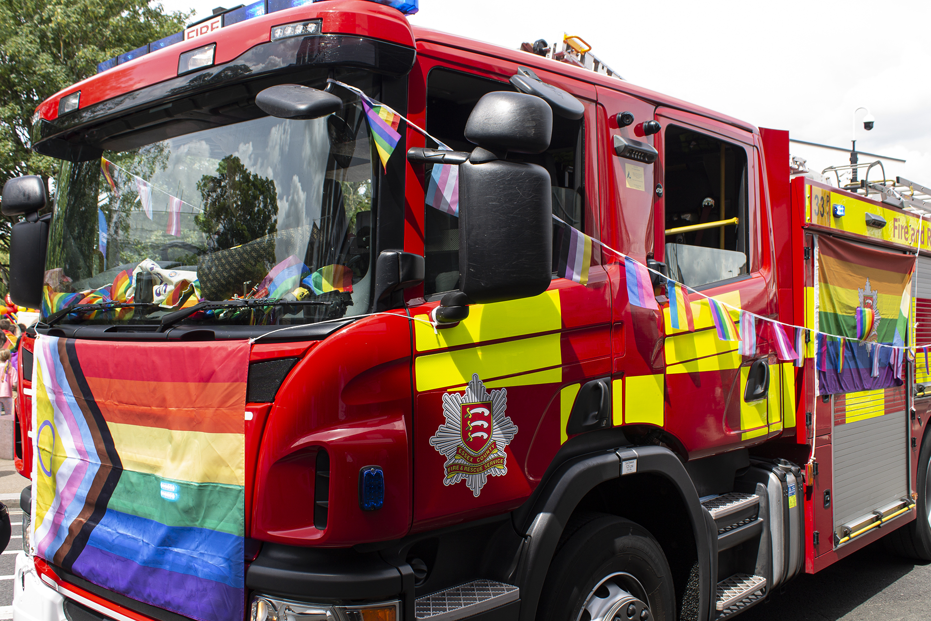 Fire engine decorated with rainbow bunting and flag for pride. 