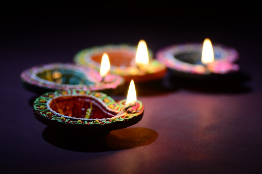 Four brightly coloured candles lit to celebrate Diwali