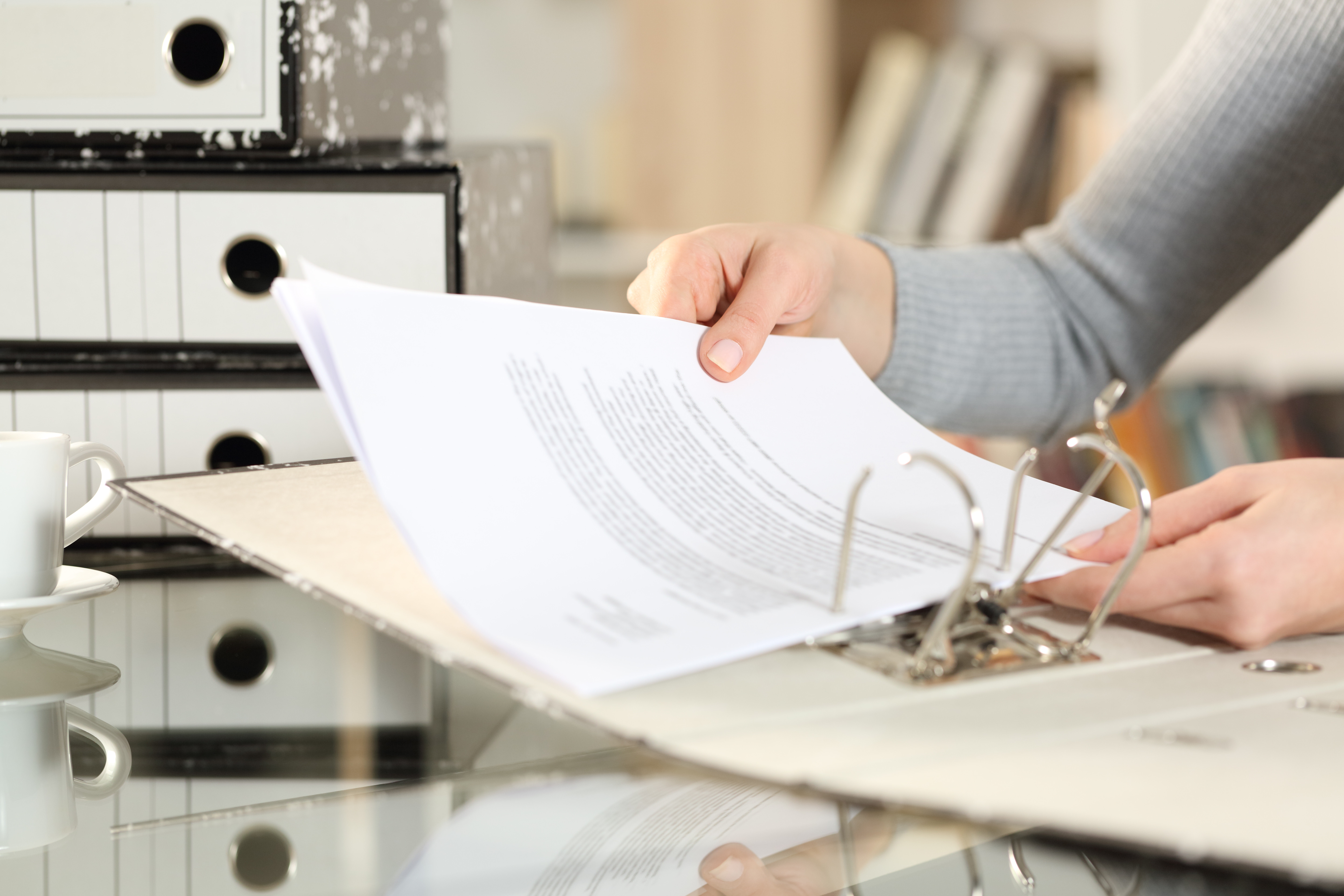 Two hands putting paper into a folder