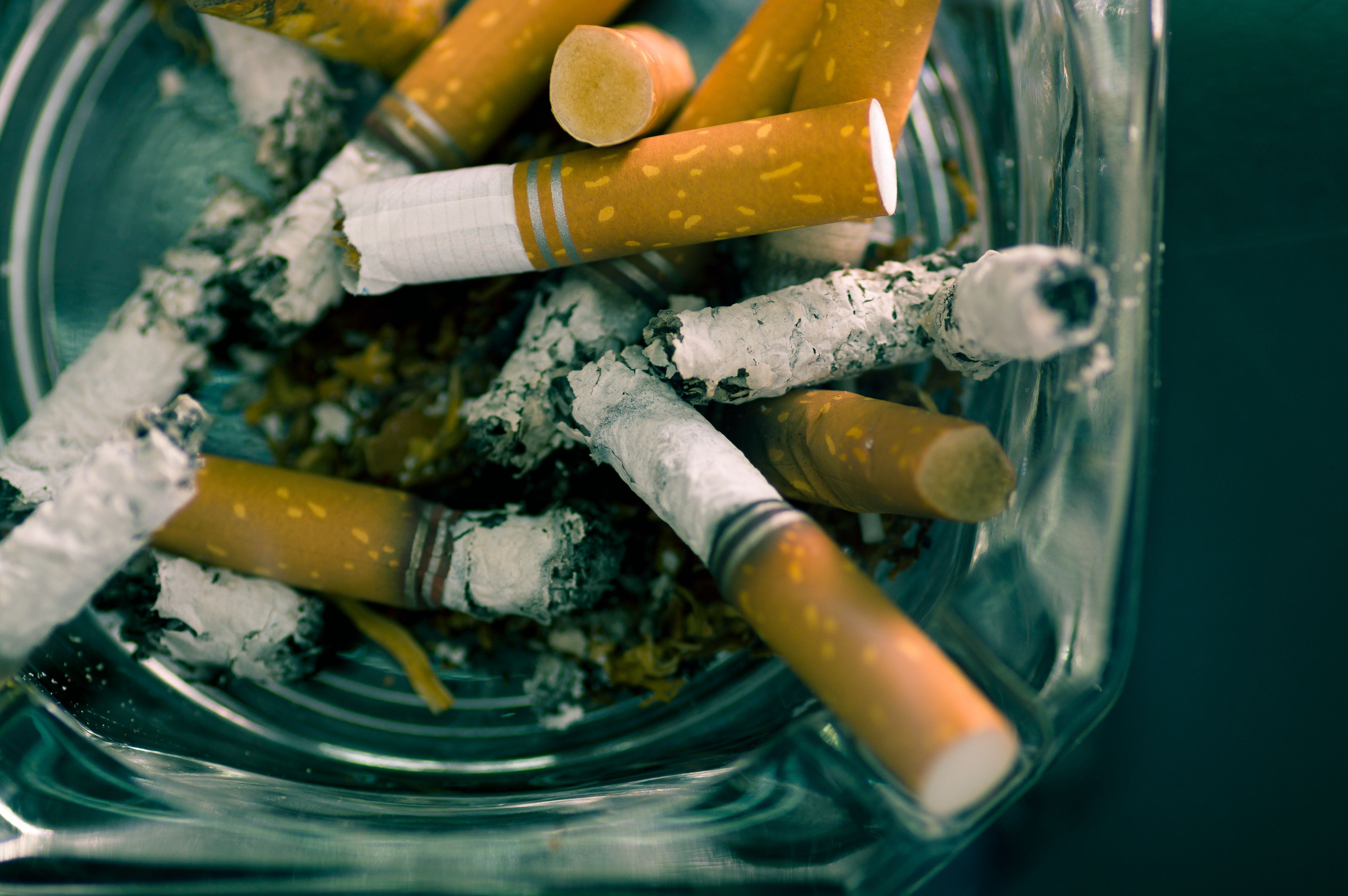 Series of cigarette butts in glass ashtray