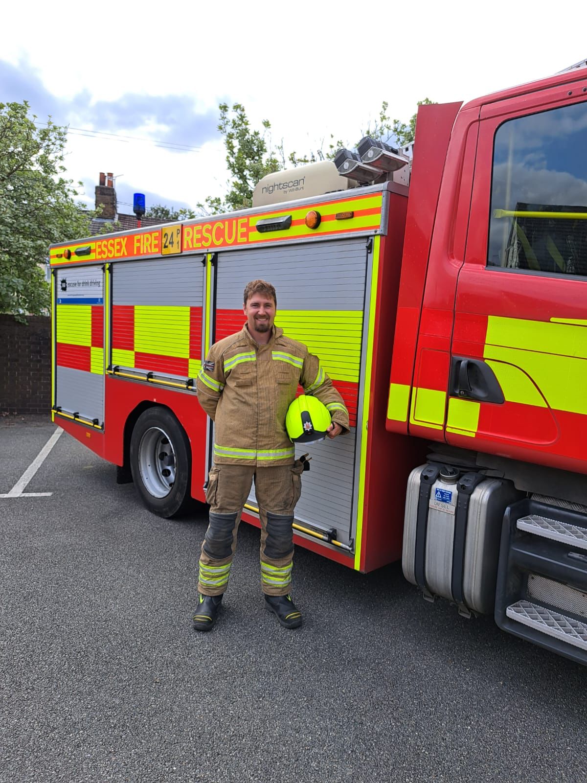 Firefighter Sam Hogwood in front of a fire engine