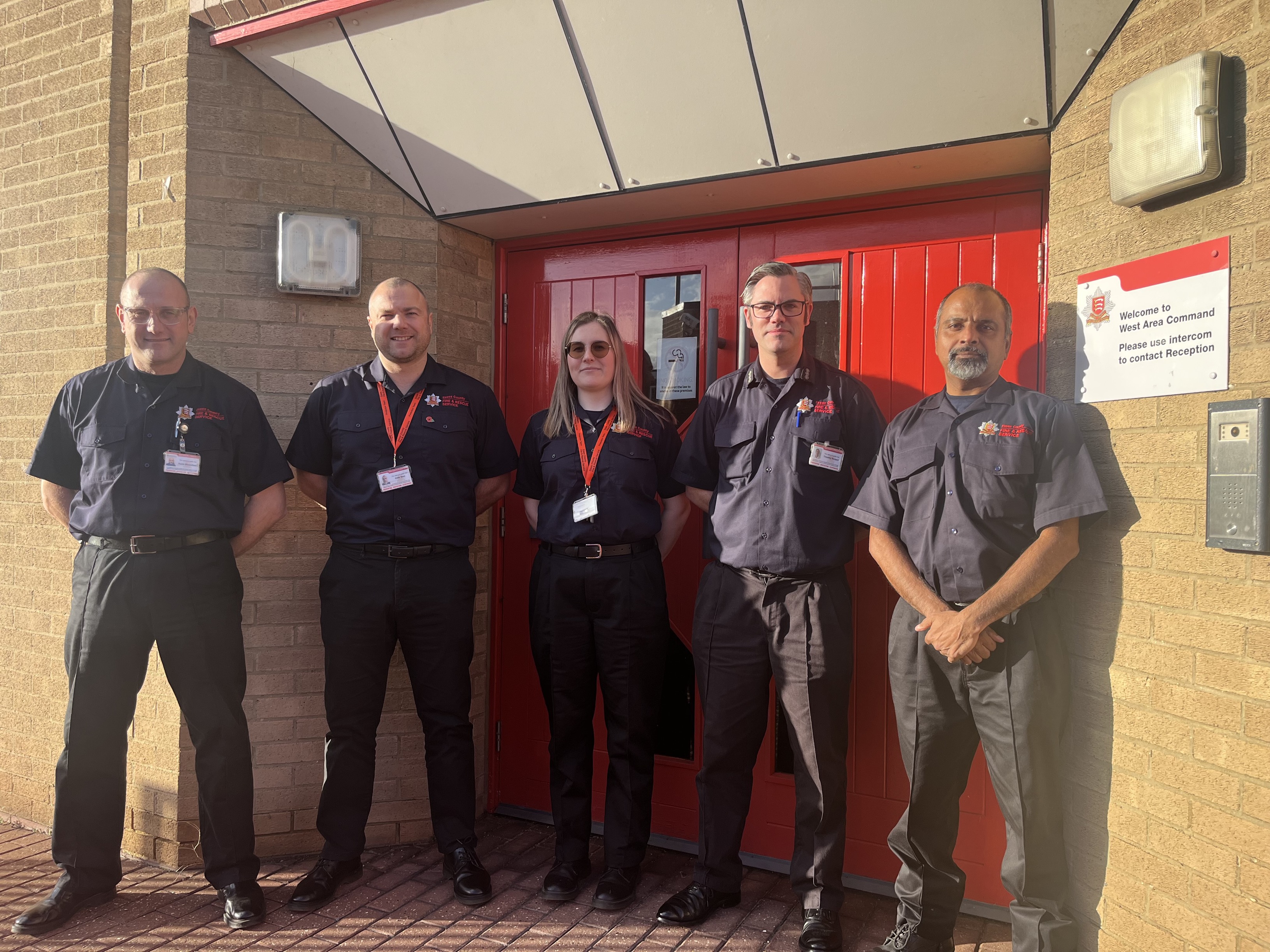 fire officers standing in front of a high rise building