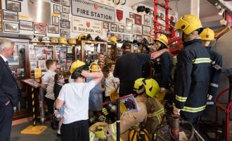 Children looking on as a museum volunteer describes an artefact.