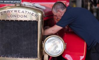 Man learning into the engine of an Albon Merryweather fire engine.