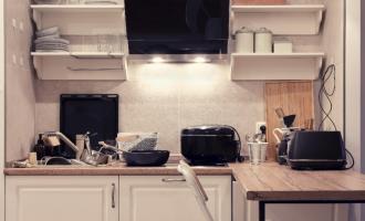 A kitchen with lots of mess on the work surfaces