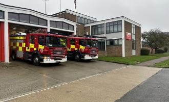 Brick fire station with two fire engines parked outside