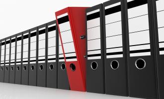 Line of twelve black folders with a red one in the middle