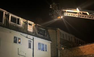 Aerial ladder platform being used to pour water through the window