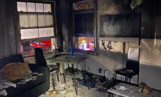 A lounge scene including a sofa and table completely damaged by fire