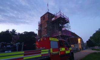 Manningtree's off road vehicle outside the church, which is covered in scaffolding. 