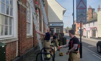 Manningtree Crew pitching ladders against buildings to put up bunting