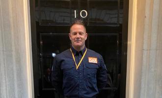 Scott Meekings stands outside No. 10 Downing Street's famous black door
