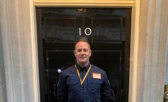 Scott Meekings stands outside No. 10 Downing Street's famous black door