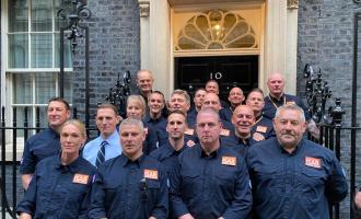 A large group of members from UKISAR stand outside No. 10 Downing Street