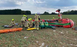 An aircraft crashed in the middle of a field with firefighters around it