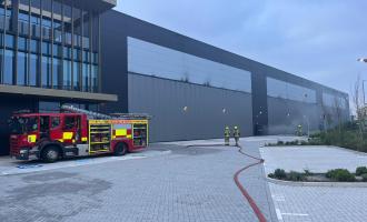 A fire engine outside a large warehouse