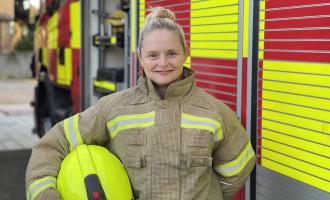 Firefighter Teresa Claxton standing in front of a fire engine