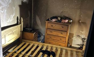 A fire and smoke damaged bedroom after a cigarette caught bedding alight