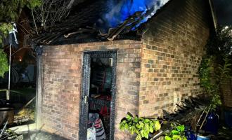 A brick outbuilding with smoke coming from the roof