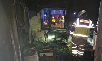 A firefighter stands in a room completely destroyed by fire