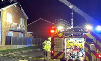 Firefighters using an Aerial Ladder Platform to extinguish a roof fire