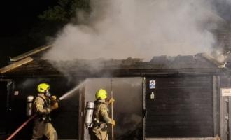 Two firefighters tackling a burning building