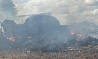 A lorry and pile of straw on fire