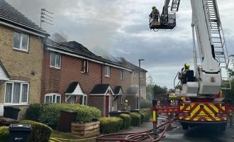 An Aerial Ladder Platform tackling the fire affecting the roofs of terraced houses