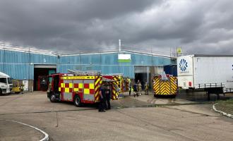 A fire engine parked infront of a large warehouse