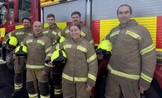 Six new on-call firefighters in front of a fire engine