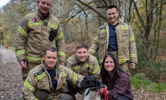 Four firefighters with Tango the dog and his owner