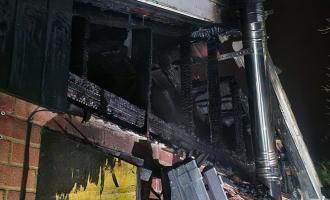 The burnt out rafter and a ladder pitched against the side of the property