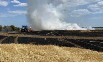 A farmer helping to create a fire break during a field fire