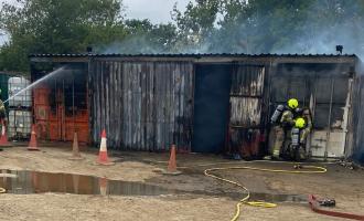 Firefighters spraying water at a smoking building
