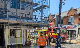 A gas engineer in Chelmsford city centre, with a fire engine in the background