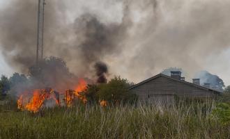 A burning wooden outbuilding