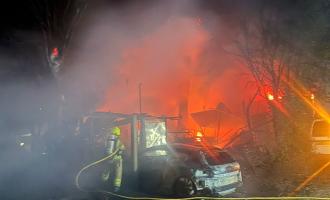 A firefighter working to put out a garden fire