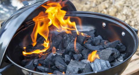 Coals burning in a kettle-shaped barbecue
