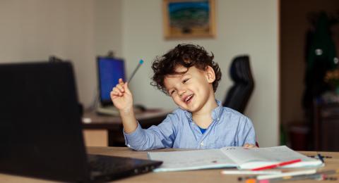 Young boy smiling at laptop