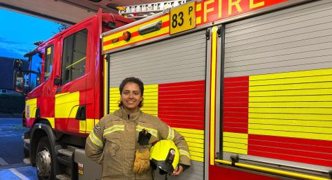 Firefighter Keegan Johnson in front of a fire engine at Stansted Fire Station