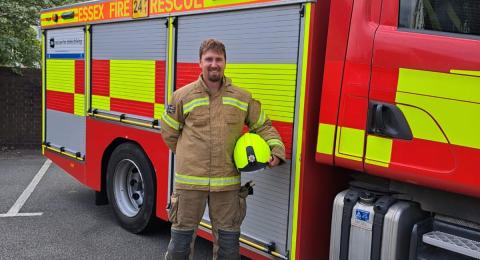 Firefighter Sam Hogwood in front of a fire engine