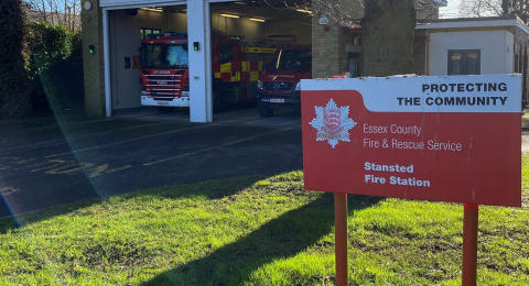 Stansted fire station in the background and a red sign with the name of the station in the foreground 