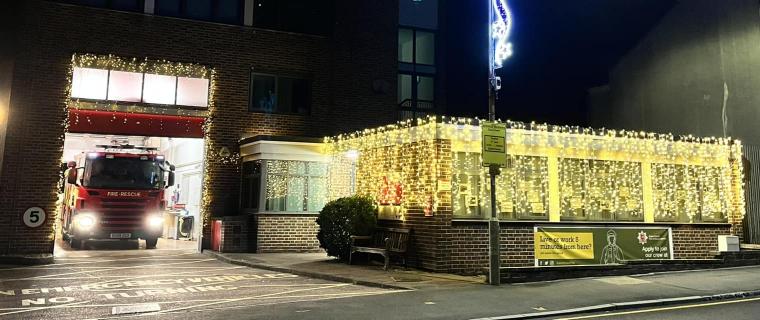 A fire station at night covered in Christmas lights