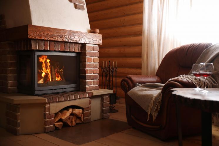 Flames in integrated log burner in a small cosy home with an armchair