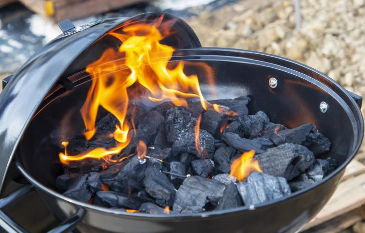 Coals burning in a kettle-shaped barbecue