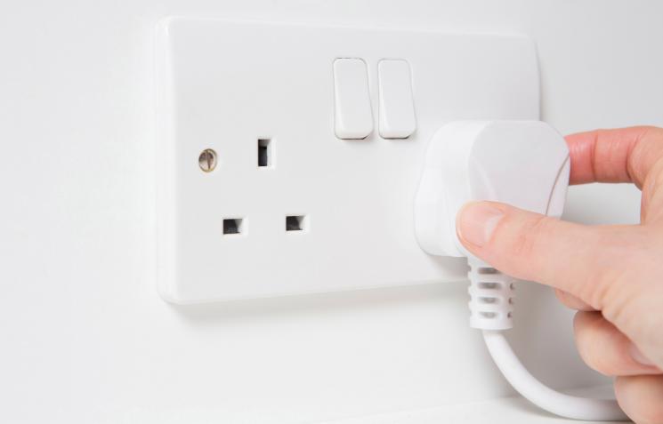 White wall with white plug in socket